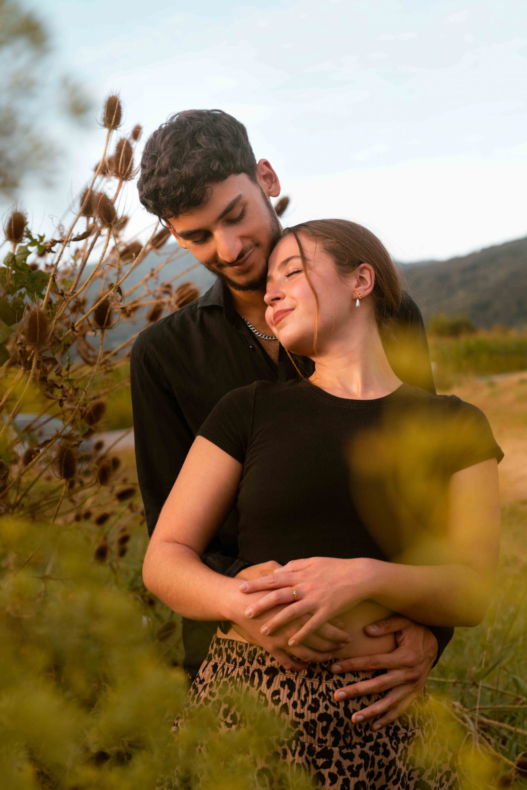 Cinematic couple portrait of a couple embracing in a meadow near Deggendorf.