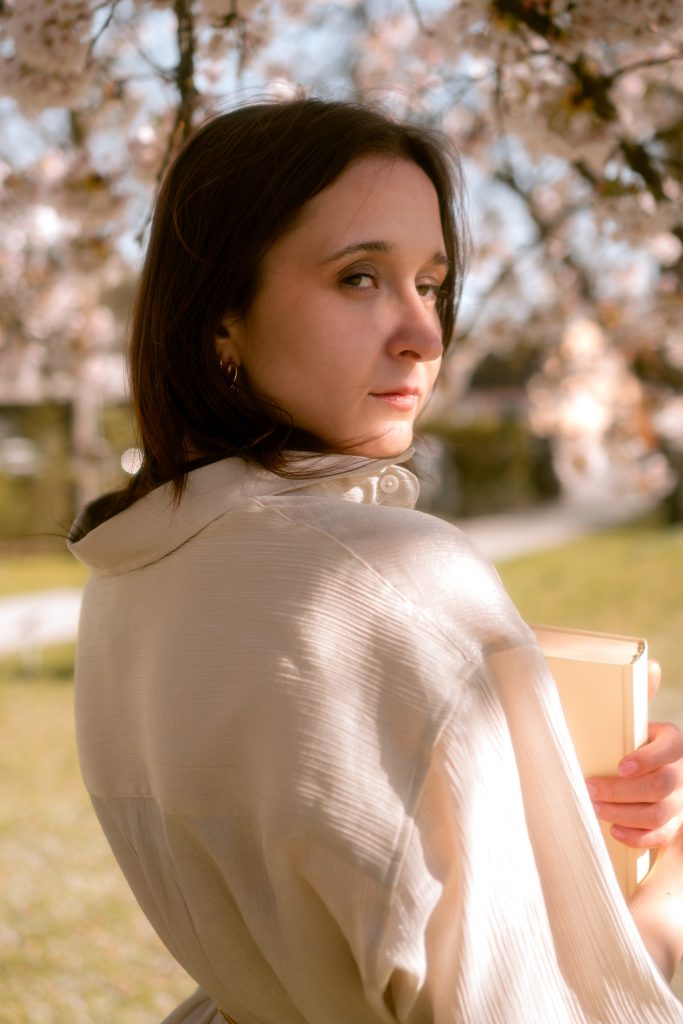 Portrait of a woman standing among cherry blossoms in Deggendorf, Germany.